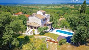 An estate of two stone houses surrounded by nature and a view of the sea 