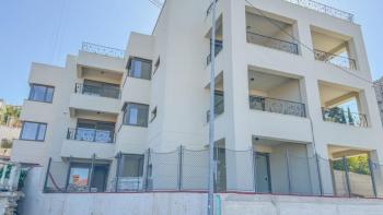 Apartment with a garden in a new building in the center of Opatija with a garage, sea view 