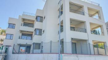 Appartement avec jardin dans un immeuble neuf au centre d'Opatija avec garage, vue mer 